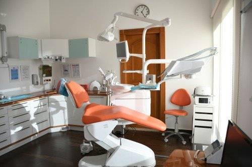 Modern Dentist Clinic with an orange dental chair and professional dental equipment