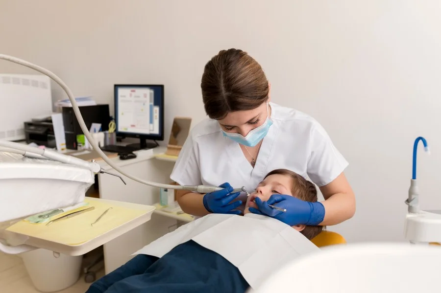 Dental surgeon examining a child’s teeth during a dental procedure.